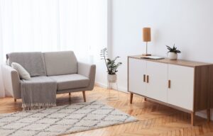 Living Room Interior Background With Comfortable Couch, Drawer And Plants