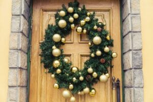 Christmas wreath with baubles and cones on a door.